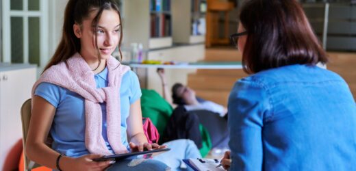 Woman school psychologist teacher talking and helping student, girl teenager